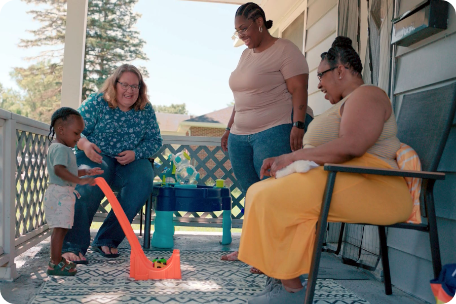 A family support provider and mother playing with a baby