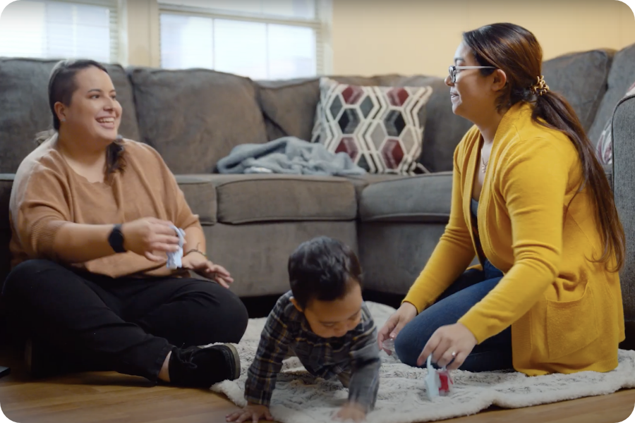 A family support provider and mother playing with a baby